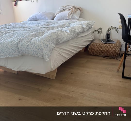 רצפת פרקט בחדר שינה עם מיטה ושולחן קטן
